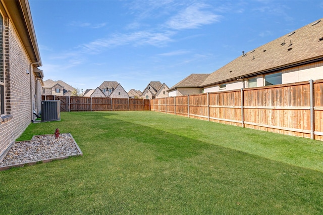 view of yard with a fenced backyard and central air condition unit