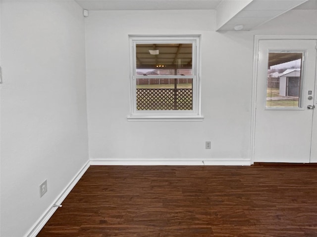 empty room with baseboards and wood finished floors