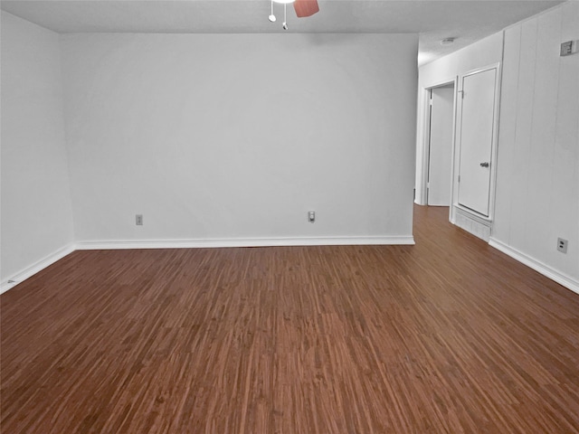 spare room featuring dark wood-type flooring, ceiling fan, and baseboards