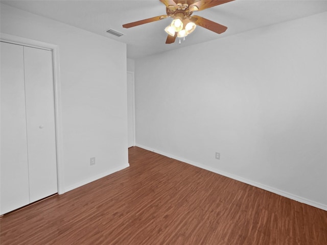 unfurnished bedroom with baseboards, visible vents, ceiling fan, wood finished floors, and a closet