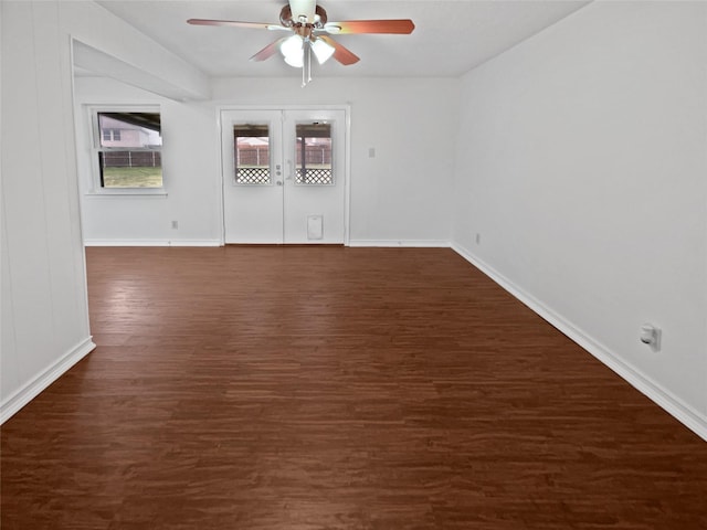 unfurnished room featuring a ceiling fan, dark wood-style flooring, baseboards, and french doors