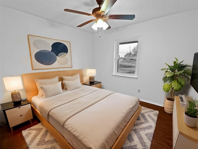 bedroom with ceiling fan and dark wood finished floors