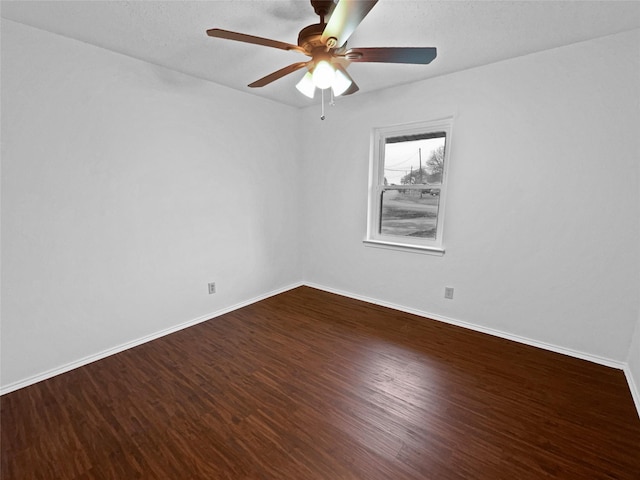 empty room with a ceiling fan, baseboards, and wood finished floors