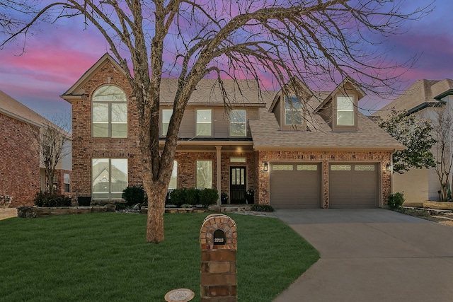 view of front facade featuring driveway, a front lawn, roof with shingles, and brick siding