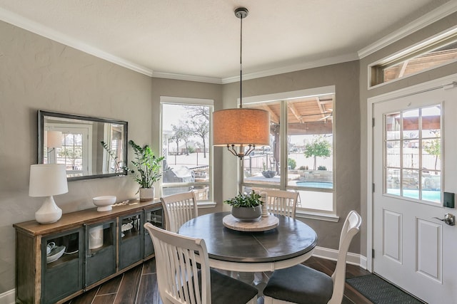 dining area with ornamental molding, dark wood finished floors, and baseboards