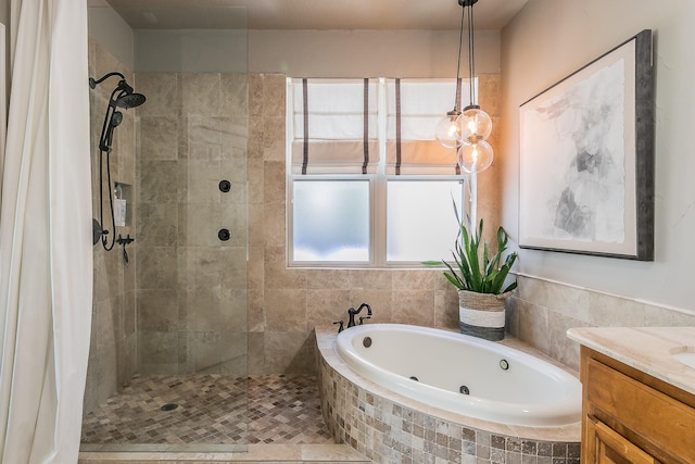 bathroom featuring a jetted tub, tiled shower, and vanity