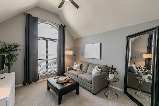 living area with light carpet, lofted ceiling, a ceiling fan, and baseboards