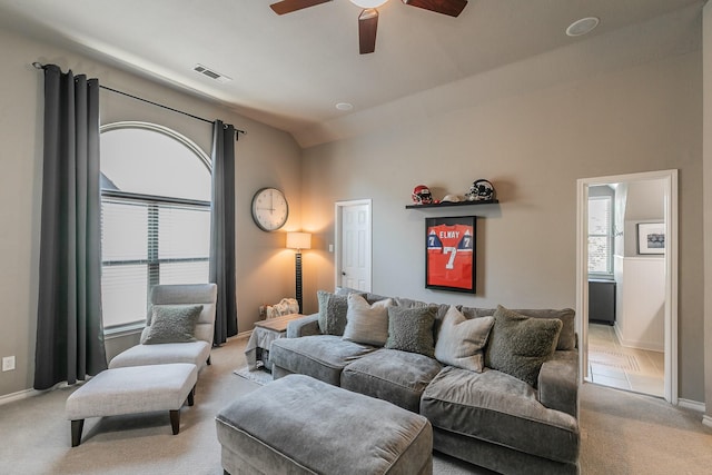 living room featuring light carpet, baseboards, visible vents, and vaulted ceiling