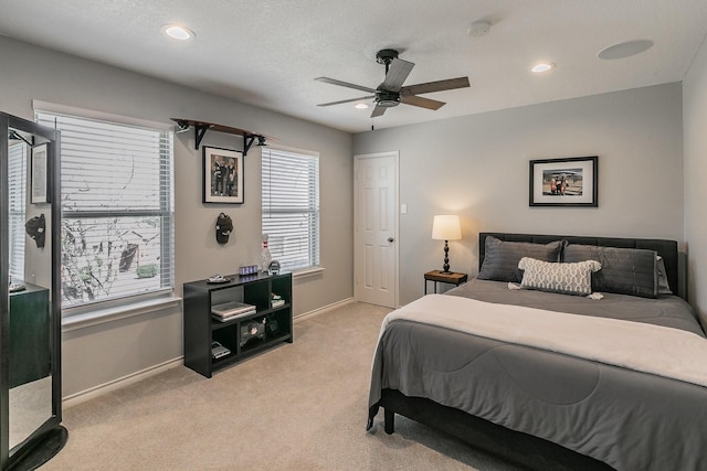 bedroom featuring a textured ceiling, recessed lighting, light carpet, a ceiling fan, and baseboards