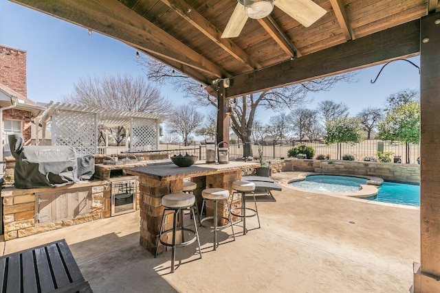 view of patio / terrace featuring a grill, a pergola, exterior kitchen, outdoor wet bar, and a fenced backyard