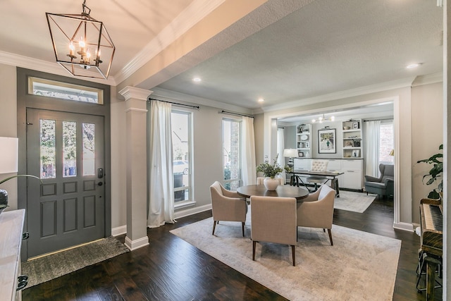 entryway with dark wood-type flooring, a healthy amount of sunlight, decorative columns, and crown molding