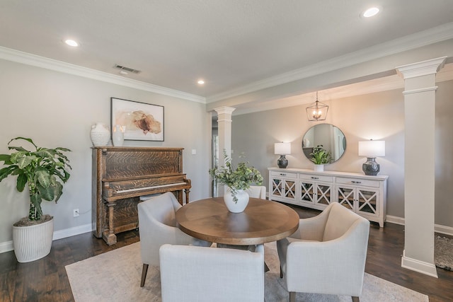 dining room with ornamental molding, visible vents, decorative columns, and wood finished floors