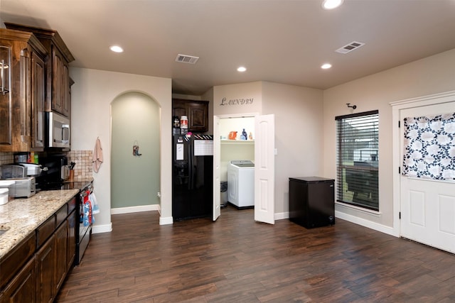 kitchen featuring dark brown cabinetry, dark wood-type flooring, visible vents, black appliances, and washer / dryer