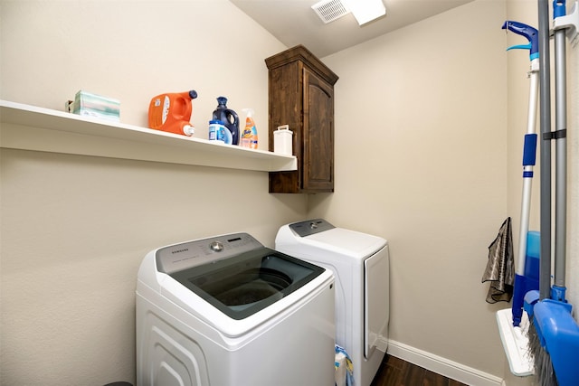 laundry room with washing machine and clothes dryer, cabinet space, visible vents, dark wood-type flooring, and baseboards