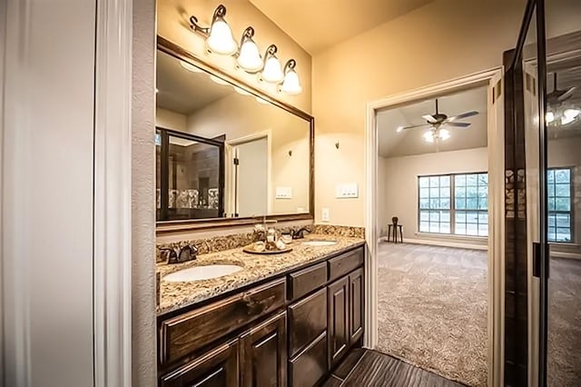 bathroom with ceiling fan, lofted ceiling, a sink, and double vanity