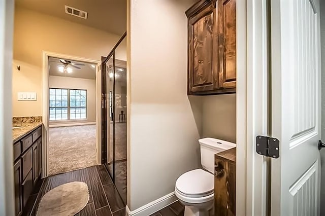 bathroom with visible vents, toilet, a shower stall, vanity, and wood finished floors