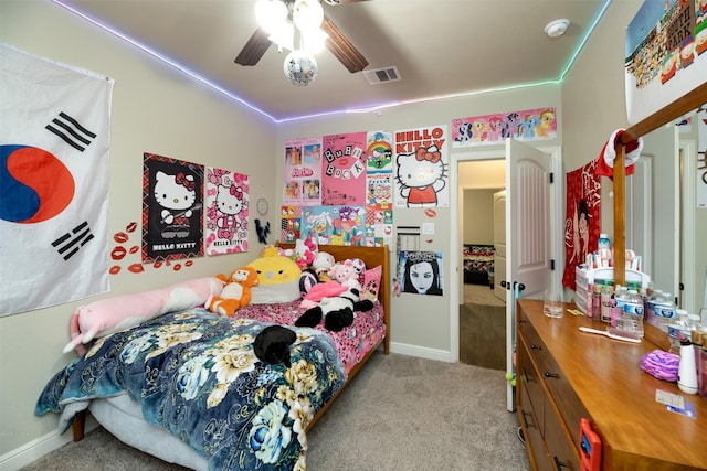 bedroom with light colored carpet, ceiling fan, visible vents, and baseboards