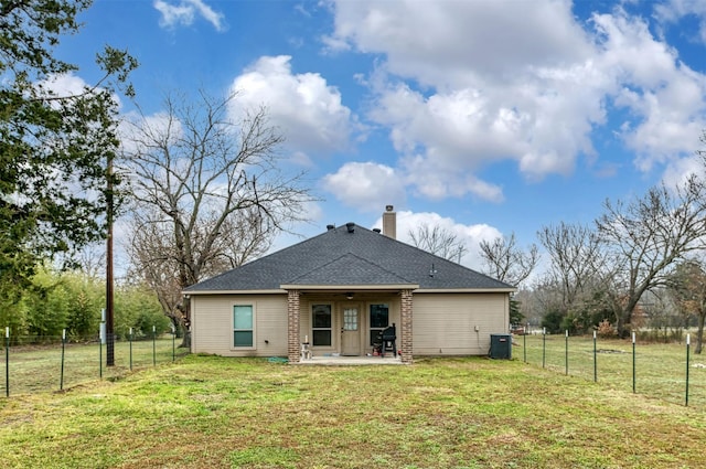 back of property featuring a yard, a fenced backyard, a patio, and a chimney