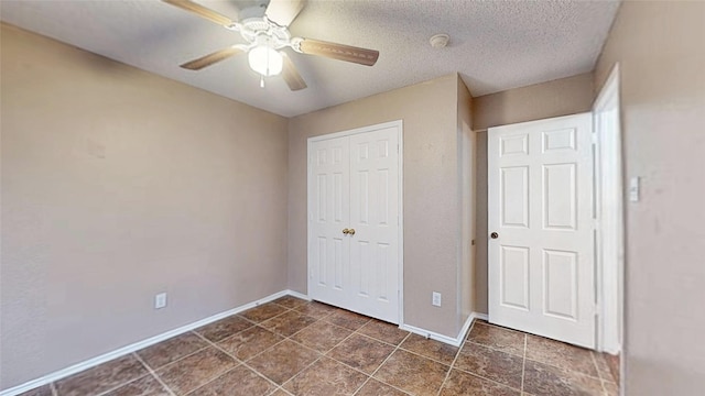 unfurnished bedroom with a ceiling fan, a textured ceiling, baseboards, and a closet