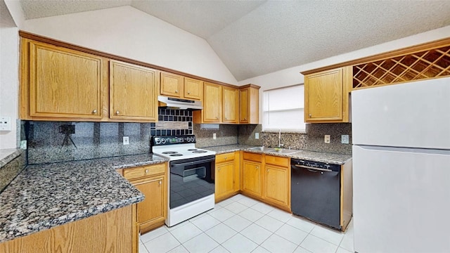 kitchen with white appliances, dark stone counters, lofted ceiling, under cabinet range hood, and a sink