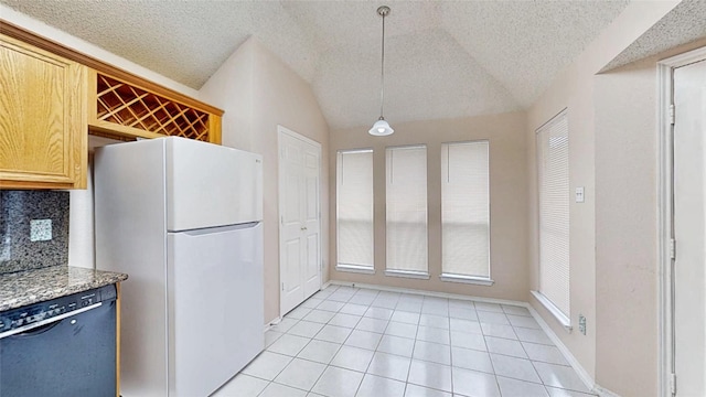 kitchen featuring tasteful backsplash, dishwasher, freestanding refrigerator, hanging light fixtures, and vaulted ceiling