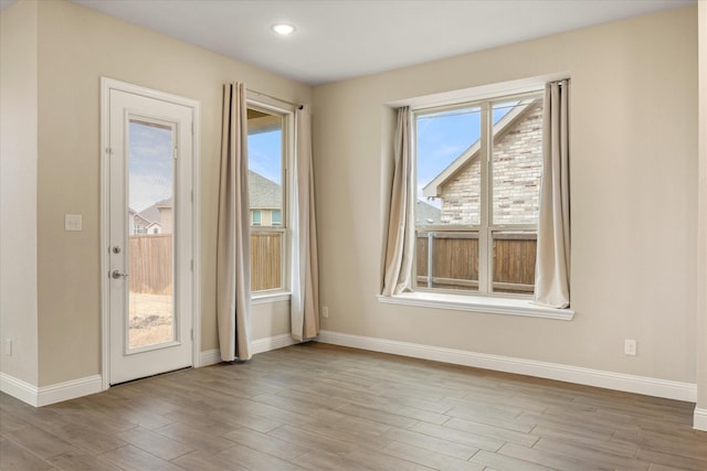 unfurnished room featuring a wealth of natural light and wood finished floors