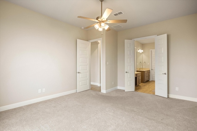 unfurnished bedroom with light carpet, ensuite bath, baseboards, and visible vents