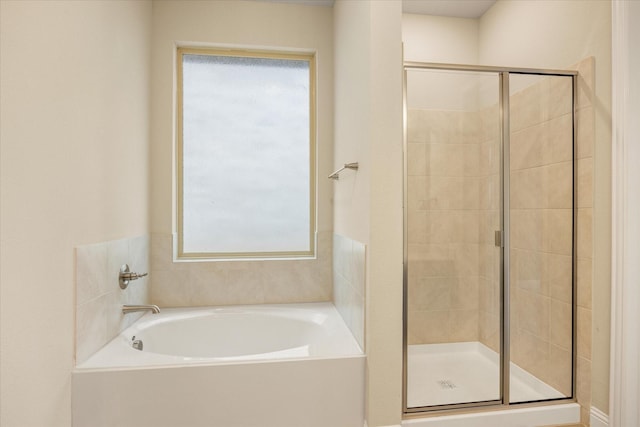 bathroom featuring a stall shower and a bath