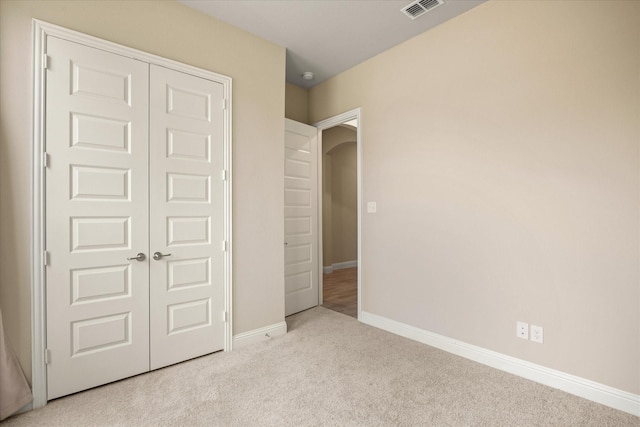 unfurnished bedroom featuring a closet, carpet, visible vents, and baseboards