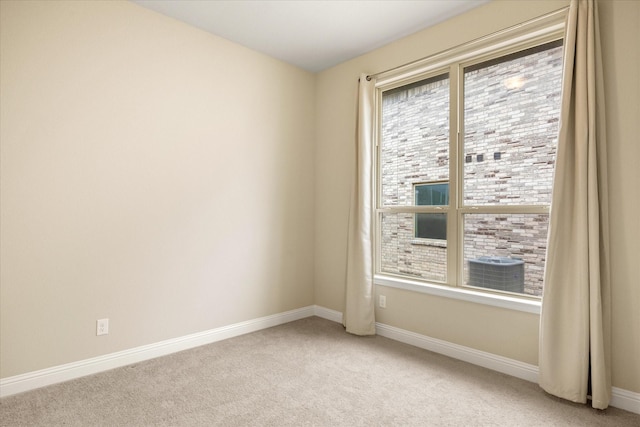 spare room with light carpet, plenty of natural light, and baseboards