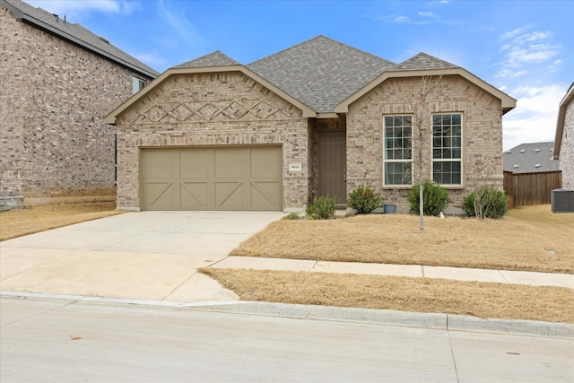 view of front facade featuring brick siding, a shingled roof, concrete driveway, fence, and a garage