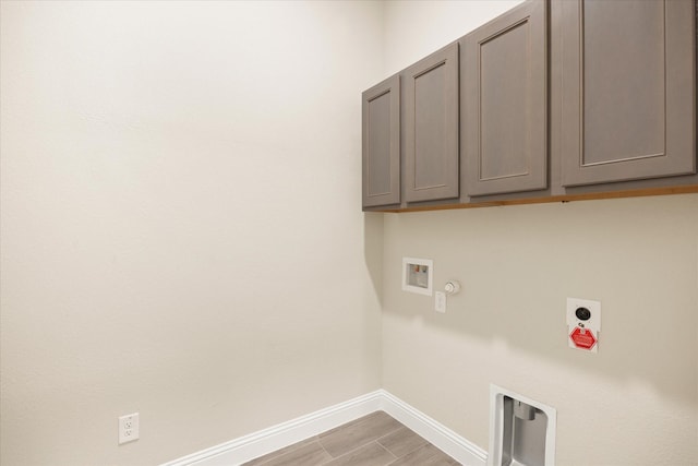 clothes washing area featuring cabinet space, baseboards, gas dryer hookup, hookup for a washing machine, and hookup for an electric dryer