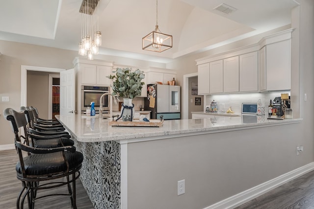 kitchen with baseboards, smart refrigerator, visible vents, and backsplash