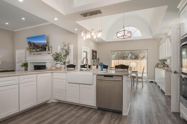 kitchen with white cabinets, dark wood finished floors, stainless steel dishwasher, a sink, and recessed lighting