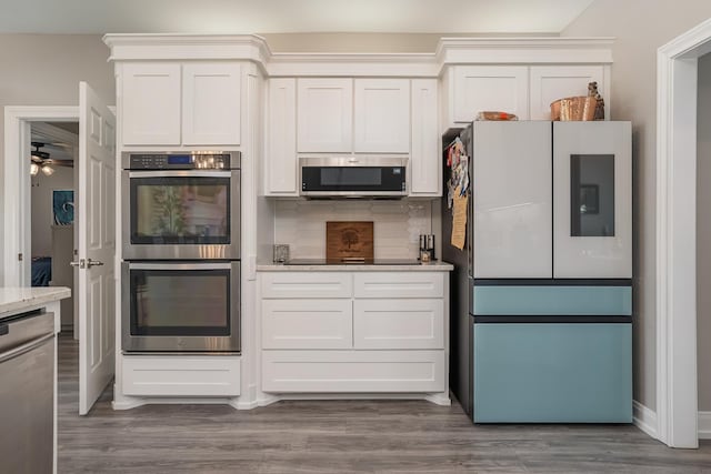 kitchen with light stone countertops, tasteful backsplash, appliances with stainless steel finishes, and dark wood-style flooring