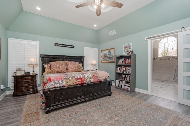 bedroom featuring lofted ceiling, baseboards, and wood finished floors