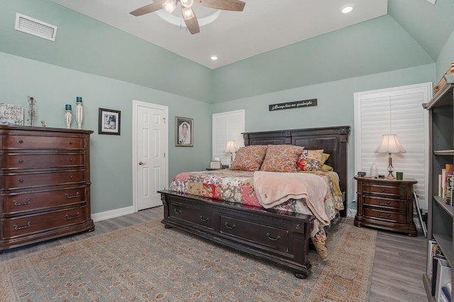 bedroom featuring lofted ceiling, visible vents, and wood finished floors