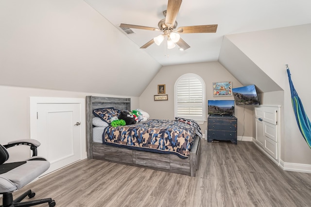 bedroom featuring visible vents, ceiling fan, vaulted ceiling, wood finished floors, and baseboards