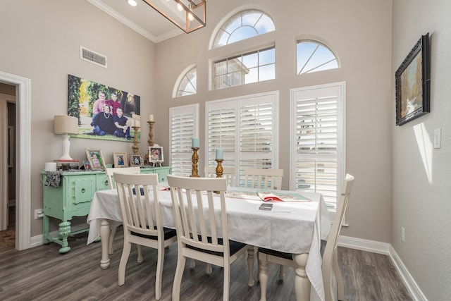 dining area featuring dark wood-style floors, a high ceiling, visible vents, and baseboards