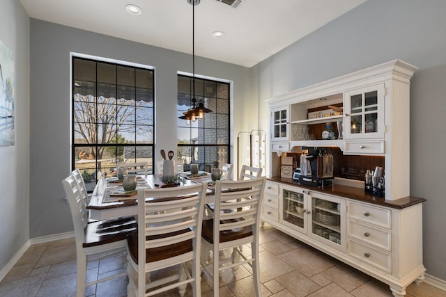 dining room featuring stone tile floors, recessed lighting, visible vents, and baseboards