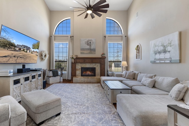 living room with a high ceiling, a fireplace, wood finished floors, and visible vents