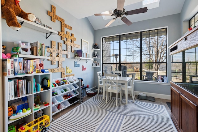 recreation room featuring vaulted ceiling, baseboards, and ceiling fan