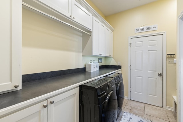 laundry area featuring stone finish floor, independent washer and dryer, cabinet space, and baseboards