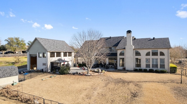 rear view of house featuring a gazebo, a chimney, fence, and a patio