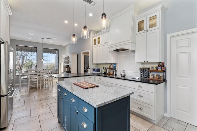 kitchen featuring blue cabinetry, white cabinetry, custom exhaust hood, and high end fridge