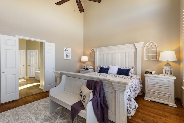 bedroom featuring ceiling fan, a high ceiling, and wood finished floors