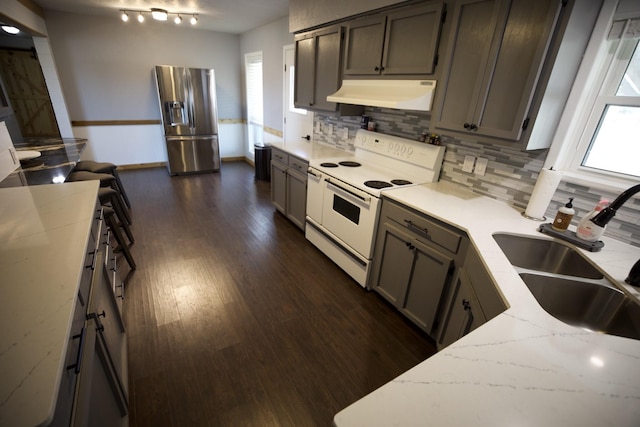 kitchen featuring white range with electric stovetop, a sink, plenty of natural light, stainless steel fridge with ice dispenser, and extractor fan