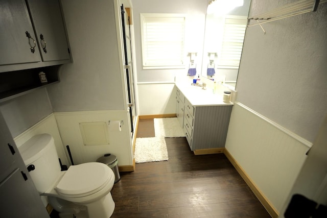 bathroom with vanity, wood finished floors, toilet, and baseboards