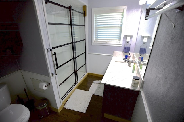 full bathroom featuring a stall shower, vanity, toilet, and wood finished floors