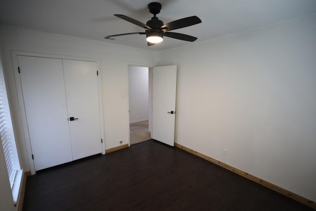 unfurnished bedroom with visible vents, baseboards, a ceiling fan, dark wood-style flooring, and a closet